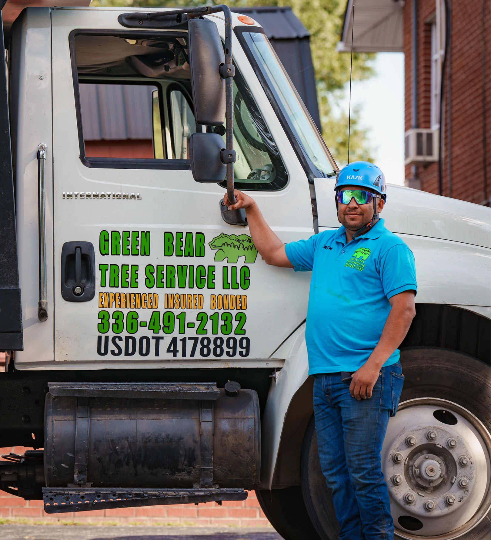Erick Ramos beside a Green Bear Tree Service truck