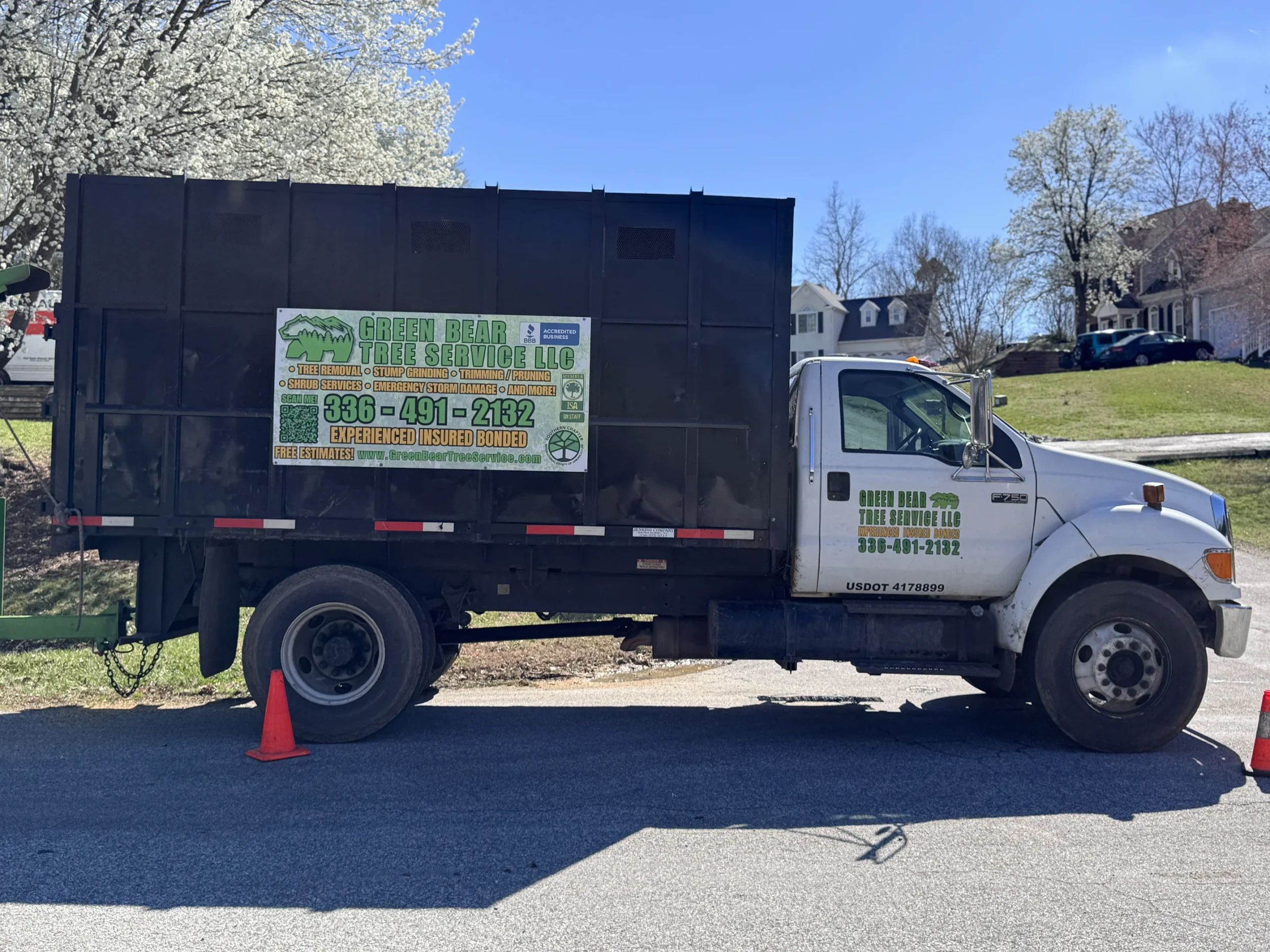 Green Bear Tree Service chip truck parked at a residential job